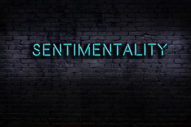 Tuğla duvara karşı duygusal yazılar yazan neon tabela. Gece görünümü