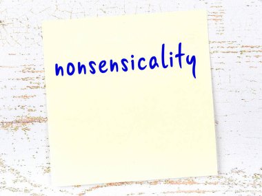 Ahşap duvardaki sarı yapışkan notta el yazısıyla yazılmış saçmalıklar var.