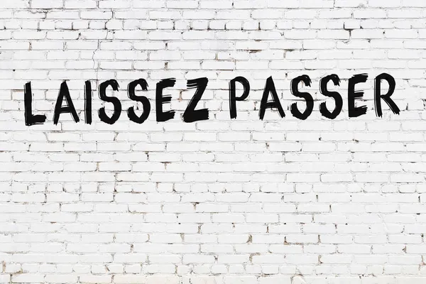 Inscripción Laissez Passer Escrito Con Pintura Negra Pared Ladrillo Blanco — Foto de Stock