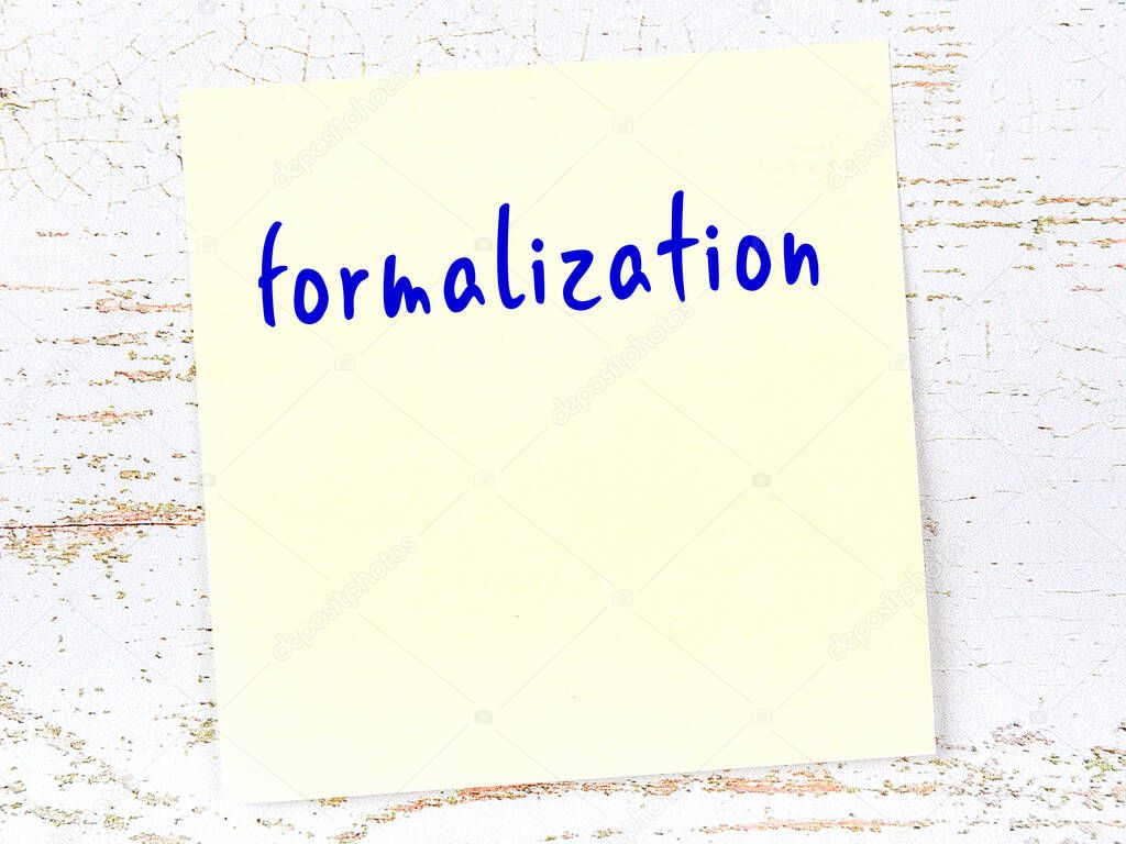 Concept of reminder about formalization. Yellow sticky sheet of paper on wooden wall with inscription