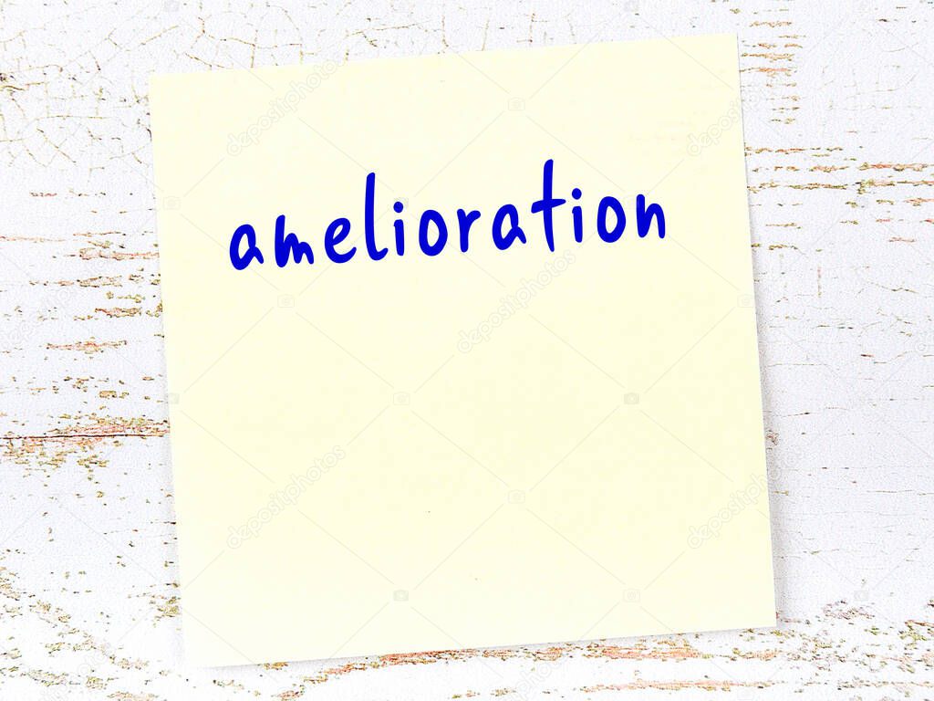 Concept of reminder about amelioration. Yellow sticky sheet of paper on wooden wall with inscription