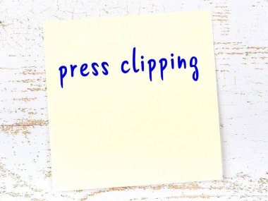 Basın kupürünü hatırlatma kavramı. Tahta duvarda üzerinde yazı olan sarı yapışkan kağıt.