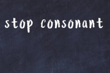 Tebeşir elle yazılmış yazıtlar siyah masada sessiz harfleri durdurur