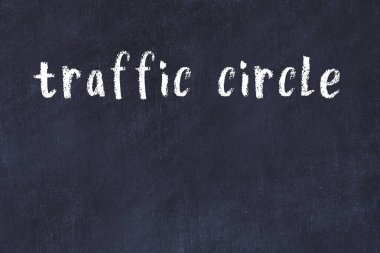 Tebeşir el yazısıyla yazılmış trafik çemberi siyah masanın üzerinde.