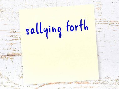 Ahşap duvarda sarı yapışkan bir not ve el yazısıyla yazılmış bir yazı var.