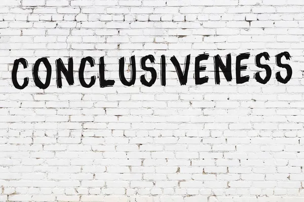 Üzerinde siyah boya bulunan beyaz tuğla bir duvar.