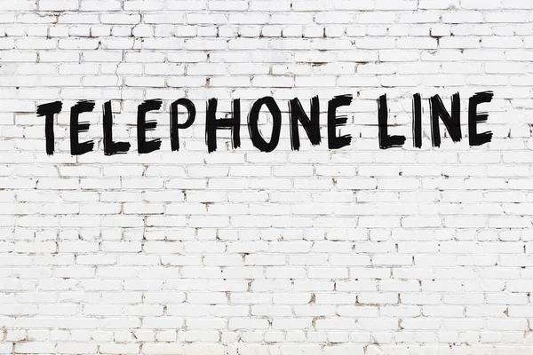 Weiße Ziegelwand Mit Aufschrift Telefonleitung Handgeschrieben Mit Schwarzer Farbe — Stockfoto