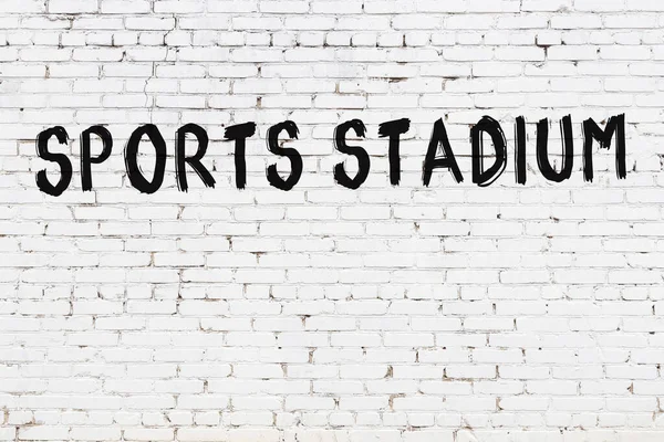 白色砖墙 上面刻有体育体育场的字样 是用黑色油漆手工写的 — 图库照片