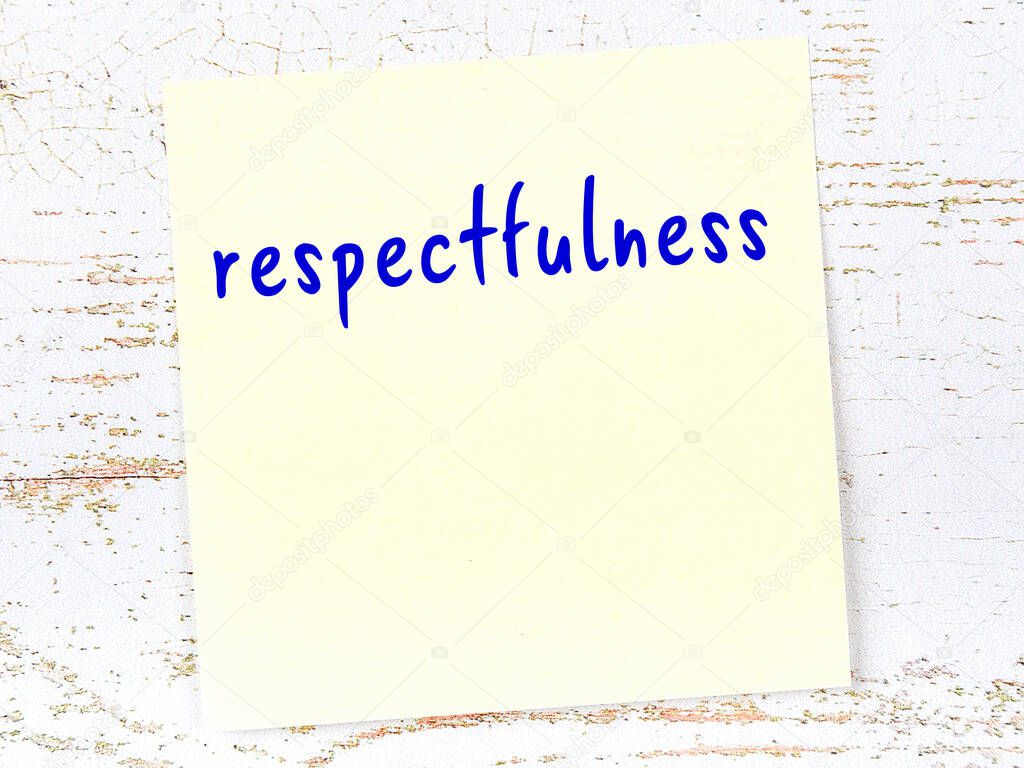 Concept of reminder about respectfulness. Yellow sticky sheet of paper on wooden wall with inscription