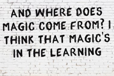 Üzerinde mantıklı alıntıların yazılı olduğu siyah boyanmış beyaz tuğla duvar.