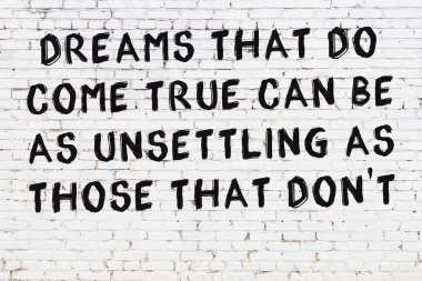 Beyaz tuğla duvar ve bilgece alıntıların yazılı olduğu siyah yazı.