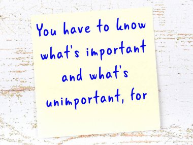 Sarı yapışkan not, ahşap duvarda el yazısıyla yazılmış zekice bir alıntıyla.