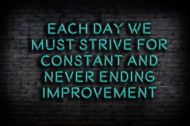 Tuğla duvardaki bilgece alıntıların neon yazıları üzerine gece görüşü