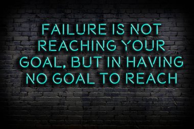 Tuğla duvardaki ışıklı neon tabela olarak bilgece alıntı