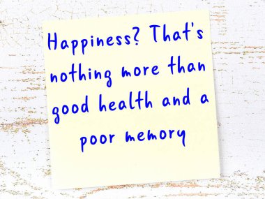 Sarı yapışkan not, ahşap duvarda el yazısıyla yazılmış zekice bir alıntıyla.