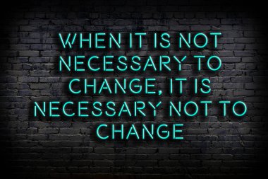 Tuğla duvardaki ışıklı neon tabela olarak bilgece alıntı