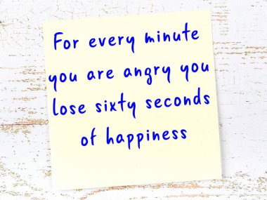 Tahta duvarda el yazısı motivasyon alıntısı olan sarı yapışkan not