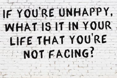 Beyaz tuğla duvar ve bilgece alıntıların yazılı olduğu siyah yazı.