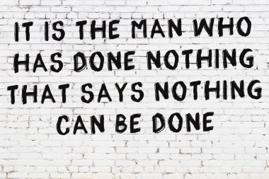 Üzerinde mantıklı alıntıların yazılı olduğu siyah boyanmış beyaz tuğla duvar.