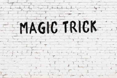 Yazılı beyaz tuğla duvar. Siyah boyayla yazılmış sihirli numara.