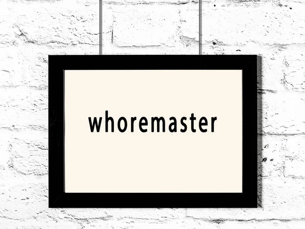 Μαύρο Ξύλινο Πλαίσιο Επιγραφή Whoremaster Κρέμεται Λευκό Τοίχο Τούβλο — Φωτογραφία Αρχείου