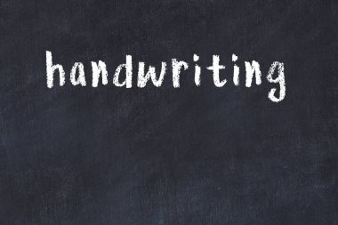 White brick wall with inscription handwriting handwritten with black paint