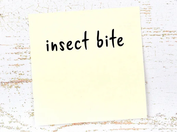 Concept Reminder Insect Bite Yellow Sticky Sheet Paper Wooden Wall — Zdjęcie stockowe