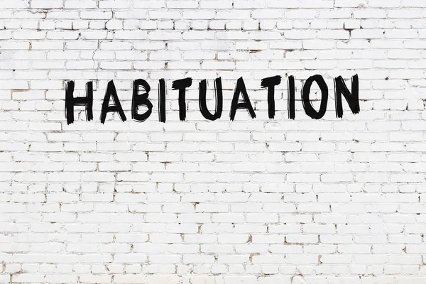 White Brick Wall Inscription Habituation Handwritten Black Paint — Fotografia de Stock