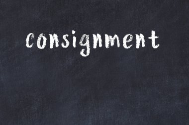 White brick wall with inscription consignment handwritten with black paint