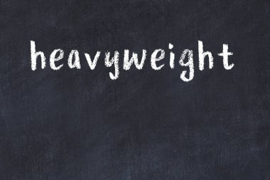 White brick wall with inscription heavyweight handwritten with black paint