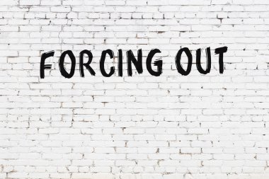 Üzerinde yazı olan beyaz tuğla duvar siyah boyayla elle yazılmış.