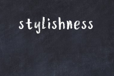 White brick wall with inscription stylishness handwritten with black paint