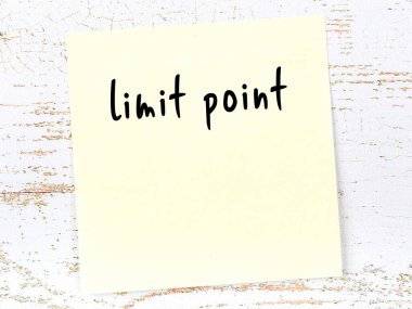 Yellow sticky note on wooden wall with handwritten inscription limit point