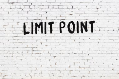 Inscription limit point written with black paint on white brick wall.