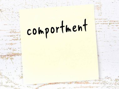 Concept of reminder about comportment. Yellow sticky sheet of paper on wooden wall with inscription