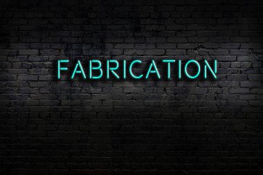 Neon sign on brick wall at night. Inscription fabrication