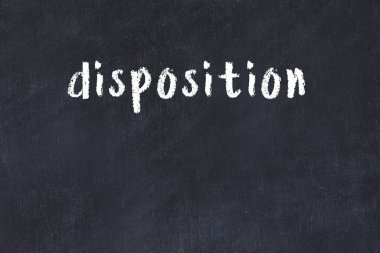 Inscription disposition written with black paint on white brick wall.