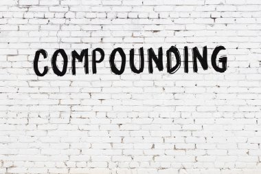 Yazı, beyaz tuğla duvara siyah boya ile yazılmış..