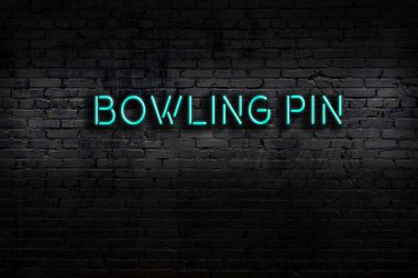 Neon sign on brick wall at night. Inscription bowling pin