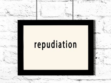 Black wooden frame with inscription repudiation hanging on white brick wall 