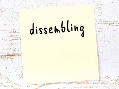 Tahta duvardaki sarı yapışkan notta el yazısıyla yazılmış bir yazı var.