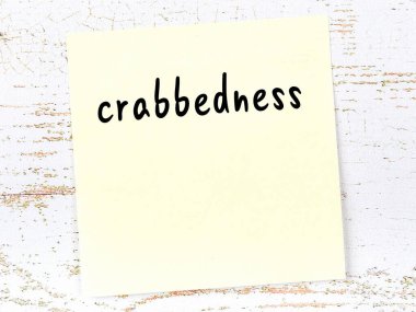 Yengeçlik hakkında hatırlatma kavramı. Tahta duvarda üzerinde yazı olan sarı yapışkan kağıt.