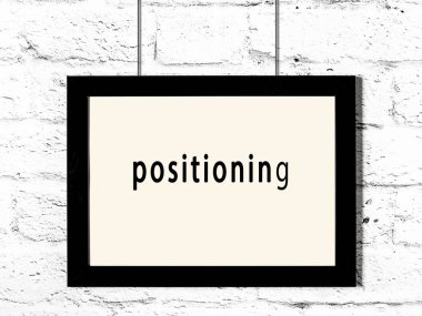 Beyaz tuğla duvara asılı siyah ahşap çerçeve. 