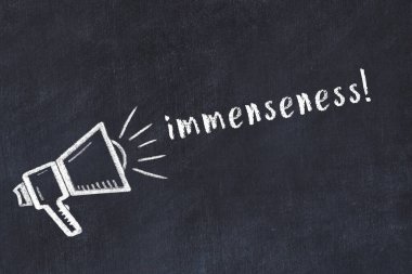 Hoparlörün tebeşir çizimi ve siyah masanın üzerine el yazısıyla yazılmış muazzam yazı.