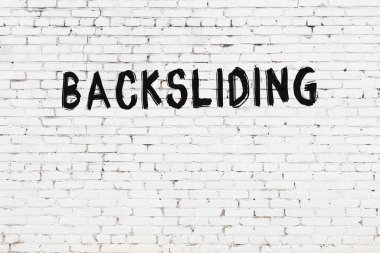 Beyaz tuğla duvara siyah boya ile yazılan yazılar.