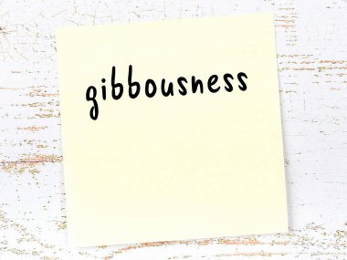 Tahta duvardaki sarı yapışkan notta el yazısıyla yazılmış devlik yazısı var.