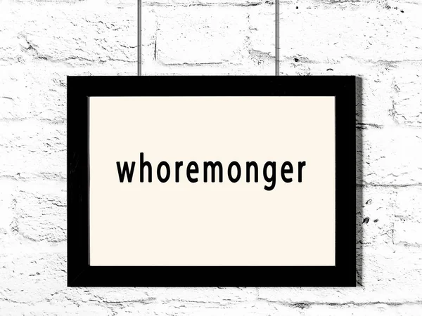 Black Wooden Frame Inscription Whoremonger Hanging White Brick Wall — Stockfoto