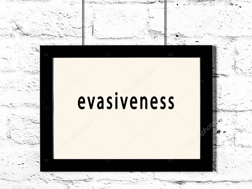 Black wooden frame with inscription evasiveness hanging on white brick wall 