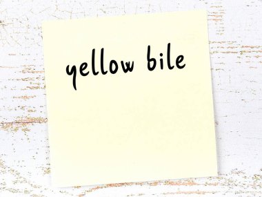 Tahta duvardaki sarı yapışkan notta el yazısıyla yazılmış sarı safra.