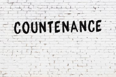 Üzerinde siyah boya olan beyaz tuğla bir duvar.